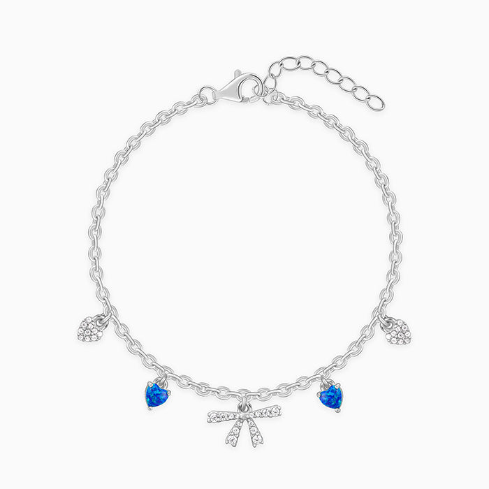 Silver bracelet with bow and heart charms, opal, and zircon