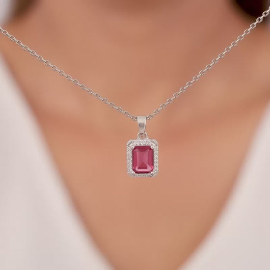 Silver pendant with red stone and zircon accents on a link chain